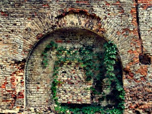 crumbling stone wall of an old house with brick masonry